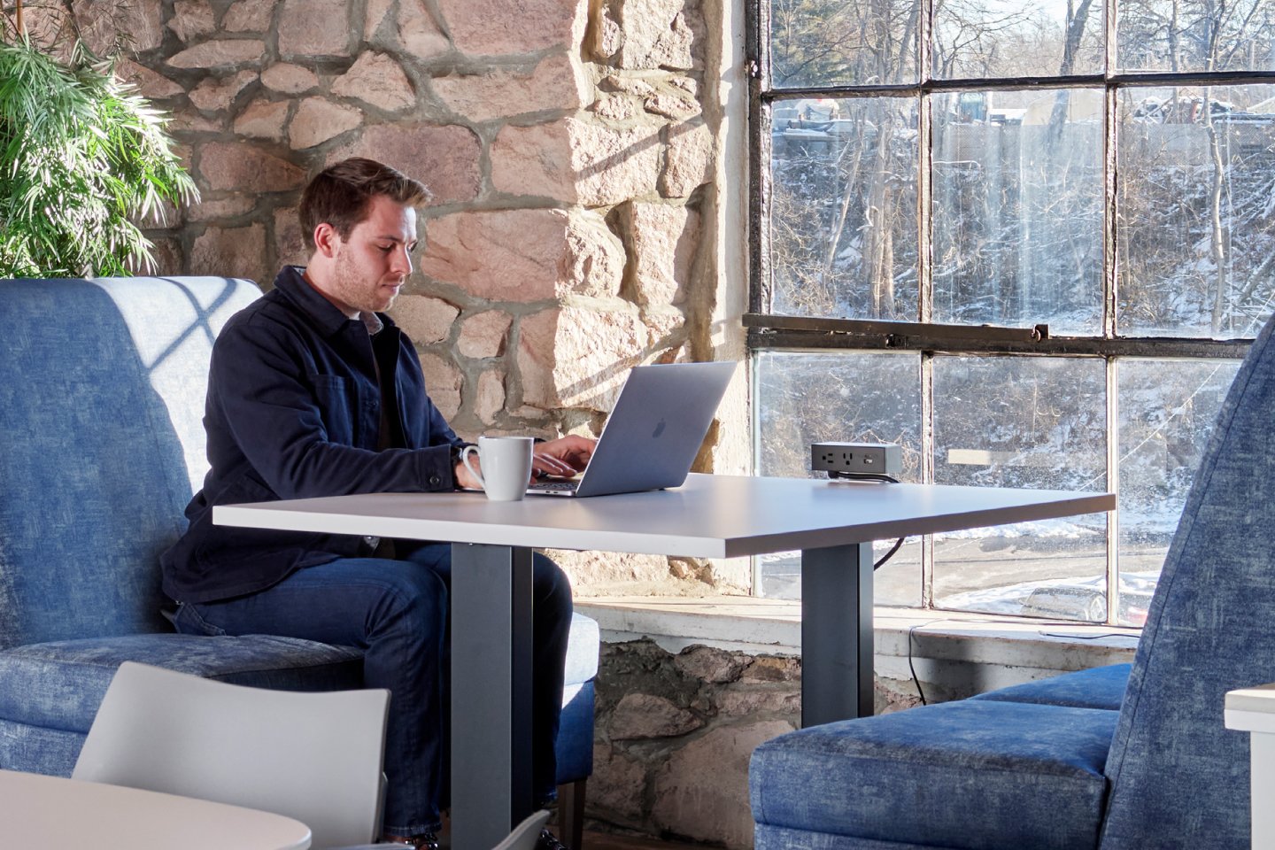Man working in third space with Affina High-Back Lounge Seating and Toggle Height Adjustable Table